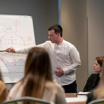 business conference or meeting in a hotel a man on a flipchart shows a development plan for company
